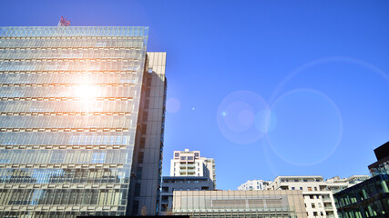 Modern office building with glass facade. Transparent glass wall of office building. Reflection of the blue sky on the facade of the building. - 756825499