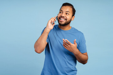 Smiling african american man in teeth braces talking during mobile phone call