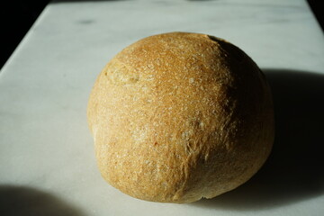 Loaf of Rustic Sourdough Bread on a White Marble Background