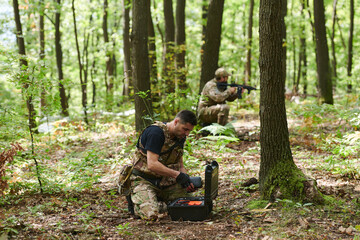 A specialized military antiterrorist unit conducts a covert operation in dense, hazardous woodland,...