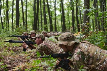 Elite soldiers stealthily maneuver through the dense forest, camouflaged in specialized gear, as...