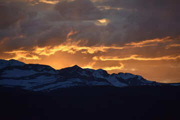 Sun Glowing Through the Clouds at Sunset Over the Rocky Mountains