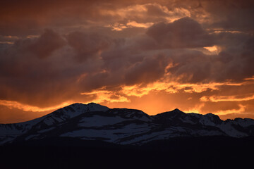 Sun Glowing Through the Clouds at Sunset Over the Rocky Mountains