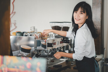 A friendly barista with a welcoming smile prepares a fresh coffee using an espresso machine in a bustling cafe environment.