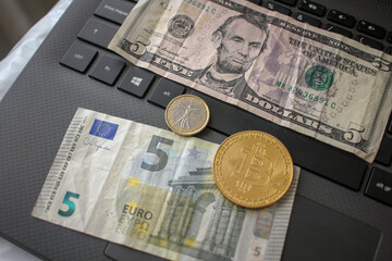 bitcoin, euro coin and five dollar and five euro bills