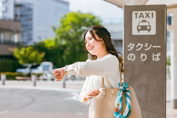 タクシー乗り場でタクシーを待つビジネスウーマン（腕時計）
 - obrazy, fototapety, plakaty