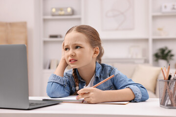 Naklejka na ściany i meble Little girl suffering from headache while doing homework at home