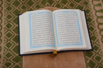 Obraz premium Holy Quran on a prayer mat. Ramadan Kareem.