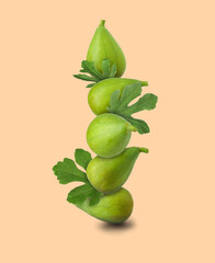 Stacked green figs and leaves on beige background
