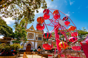 Ferris wheel in front of the main church in Andes, Colombia