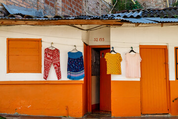 Clothes hanging on the door of a colorful house in Andes, Colombia