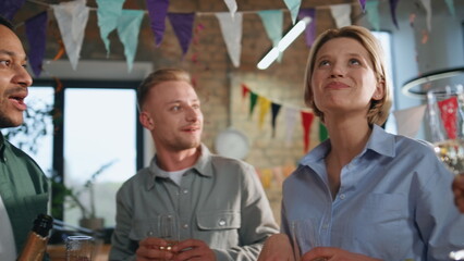 Cheerful friends talking birthday party standing festive interior close up.