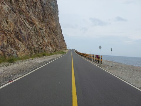 Photo of Street in Lampa Strait area, Natuna Island. The road is on a rock wall and borders the South China Sea. A scenic road leads to the harbor.