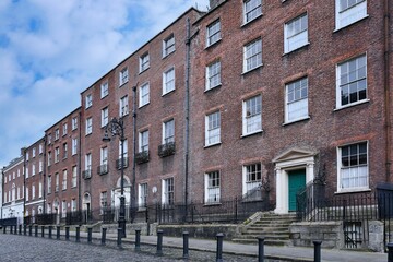 Row of 18th century brick townhouses on cobblestoned street in Dublin - 756866635