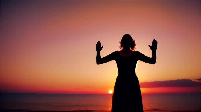 Silhouette of a person joyfully raising hands at sunset by the beach, expressing freedom and happiness