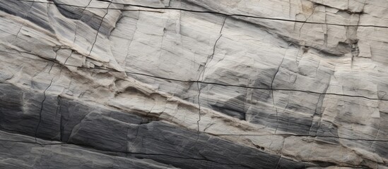 A detailed closeup of an outcrop of bedrock with a grid pattern, resembling a wall. The rock surface is textured and rugged, showcasing natural patterns and formations - obrazy, fototapety, plakaty