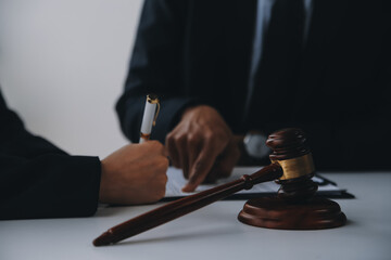 Justice and Law concept. Legal counsel presents to the client a signed contract with gavel and...