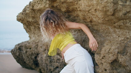 Contemporary performer dancing sensual dance at rocky shore closeup. Girl dancer