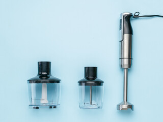 Metal blender for whipping and chopping on a blue background.