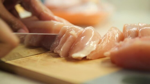 cutting chicken fillet on a chopping board 