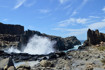 Waves crash into rock formations at Bombo on the South Coast of New South Wales, Australia.
