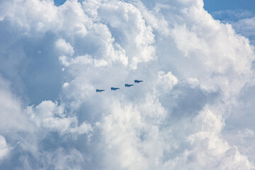 Fototapeta na wymiar 積乱雲を背景に空を飛ぶ戦闘機
