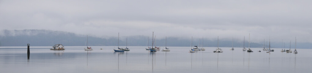 Panorama of boats in front of the shore of Cowichan Bay during a winter season on Vancouver Island...