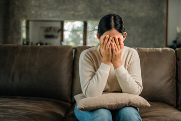 Fototapeta na wymiar Depressed and Stressed asian woman on sofa. Crying sadness female alone in home problem in life. Unhappy asian woman headache Upset frustrated by problem love relationship feeling despair and anxiety
