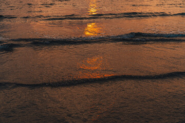 Sunset at sea with orange sky and waves