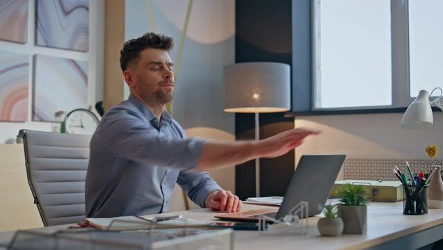 Mad guy shutting laptop lit at office closeup. Nervous angry creator ending work