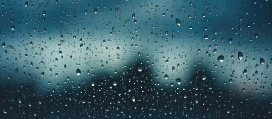 A close up of liquid droplets on a fixtures windshield, sparkling in electric blue. The moisture from the drizzle creates a beautiful precipitation scene