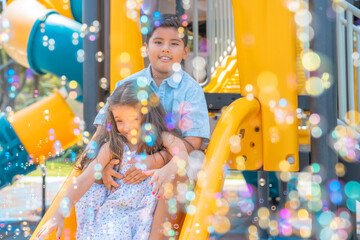 Soap bubbles and children playing on a slide