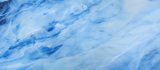 Fototapeta premium A close up of a blue and white marble texture resembling a cloudy sky with cumulus clouds. The pattern resembles a freezing meteorological phenomenon in a natural landscape