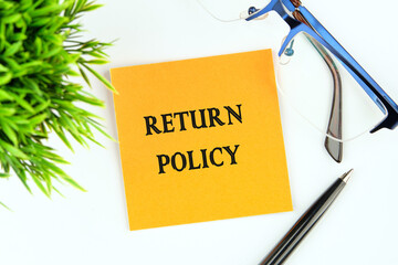 Return Policy written on an orange sticker on a white background