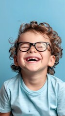 Obraz premium Portrait of a smiling little boy with glasses on a blue background
