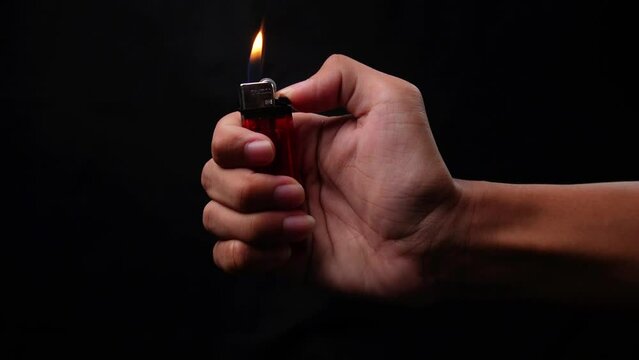 shot of hand holding and light a match with isolated black background