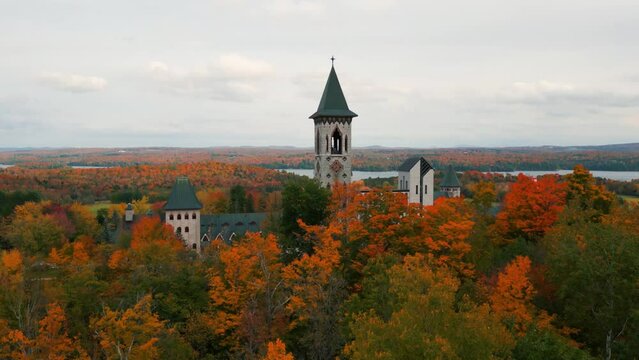 Saint Benoit du Lac abbey in Quebec province near Magog on the shore of Memphr&eacute;magog lake during autumn season with colorful trees, Canada