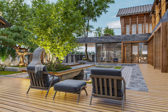 An outdoor patio with two lounge chairs and an ottoman on a wooden deck next to the pond