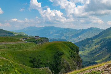 Fototapeta na wymiar Idyllic Panorama: Green Mountains Against Blue Skies