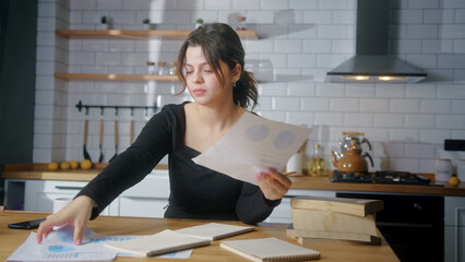 A college student sit in the kitchen studying, taking notes. Woman tired to study taking break. Study home concept	
