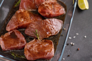 marinated Pieces of Fresh tuna Fish fillet in glass cooking dish on a kitchen table