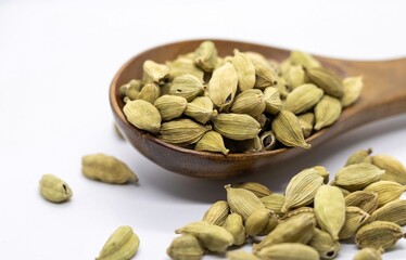 Cardamom or Cardamon in a Wooden Spoon Isolate on White Background with Copy Space
