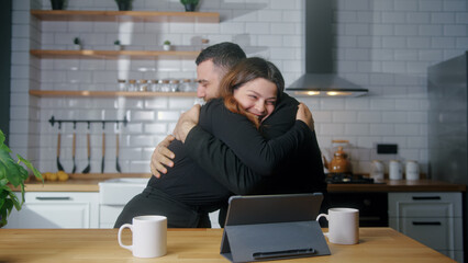 Young couple sit in kitchen use tablet read great news online received e-mail joy celebrating...