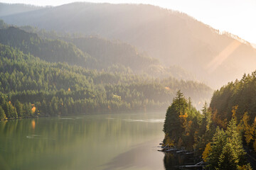 Sunlit landscape of the Columbia River with banks covered in autumn forest with fishing platforms along the river bank