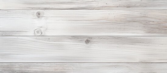 Fototapeta premium A closeup shot of a rectangular white wooden table with a blurred background. The hardwood flooring complements the elegant font of the paper products placed on the table