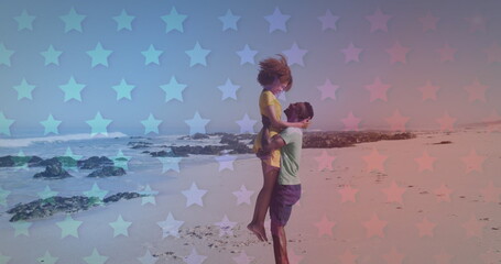 Obraz premium Young African American couple embraces on a star-patterned beach