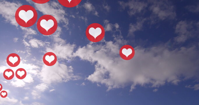 Multiple red heart icons float against a blue sky with clouds