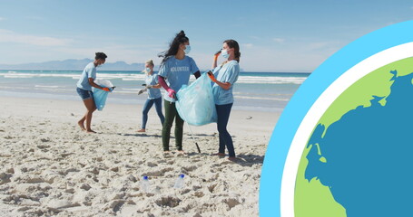 Image of globe over diverse group in face masks picking up rubbish from beach
