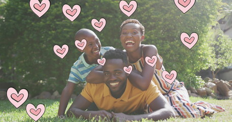 Image of hearts over happy african american family in garden