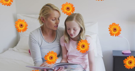 Image of flowers over caucasian mother and daughter reading book in bed